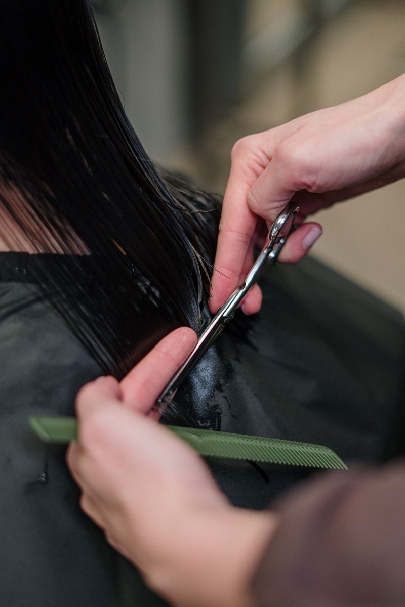 Profissional cortando os cabelos de uma mulher